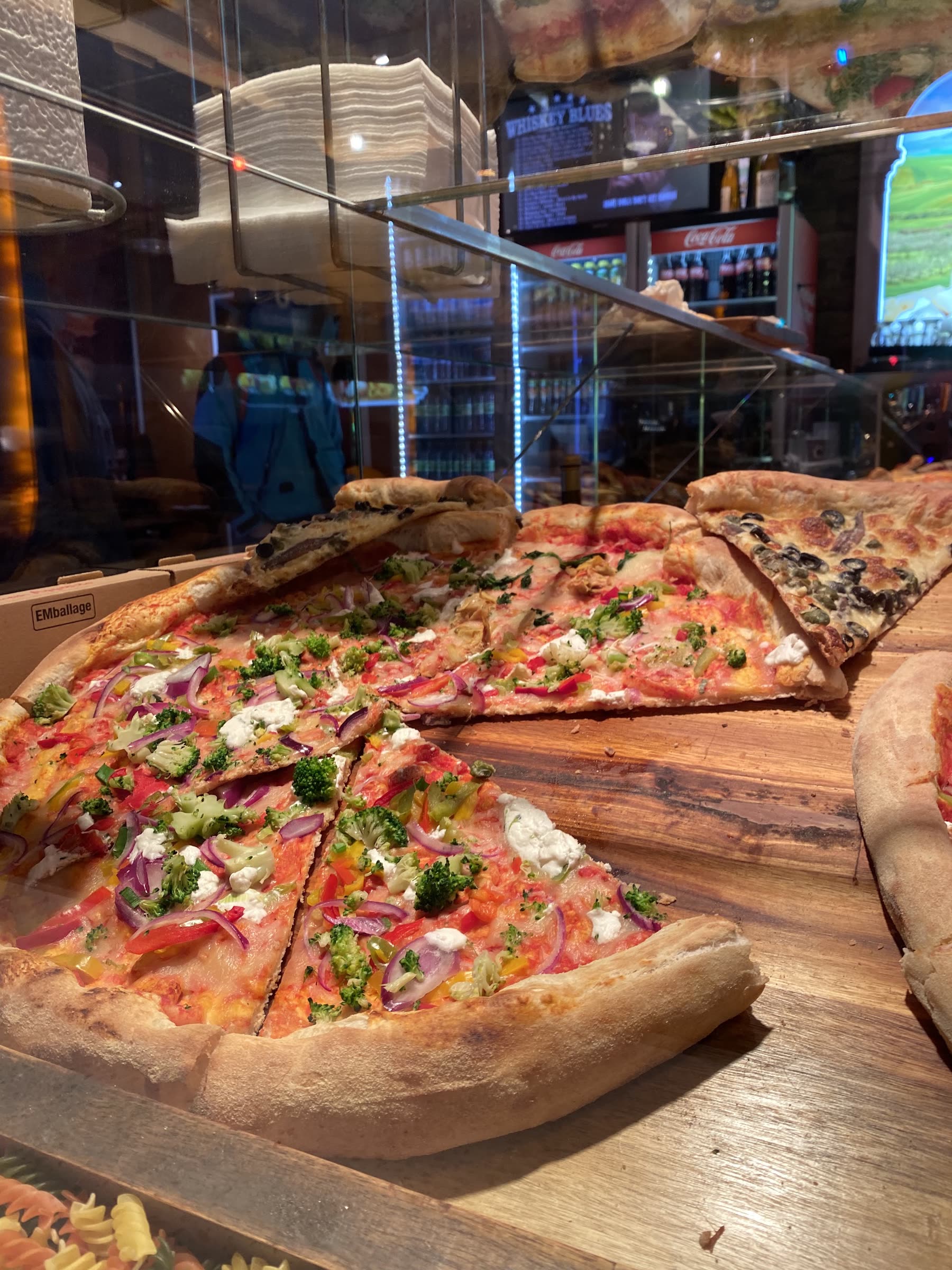 Frisch belegte Pizzableche in der Theke, Nahaufnahme